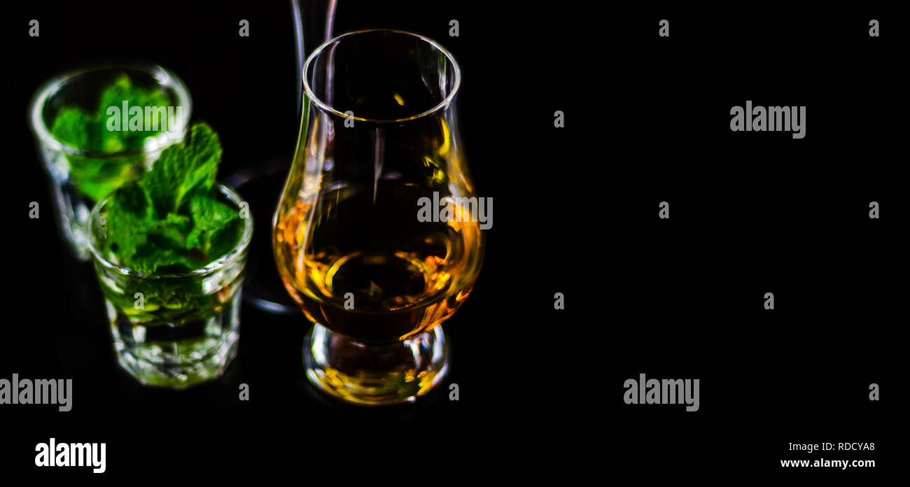 single malt whiskey in a glass and green mint liqueur, refreshing set