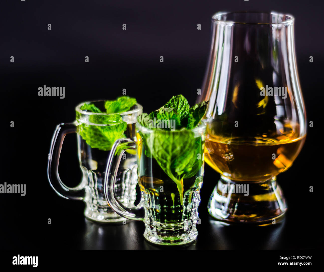 single malt whiskey in a glass and green mint liqueur, refreshing set