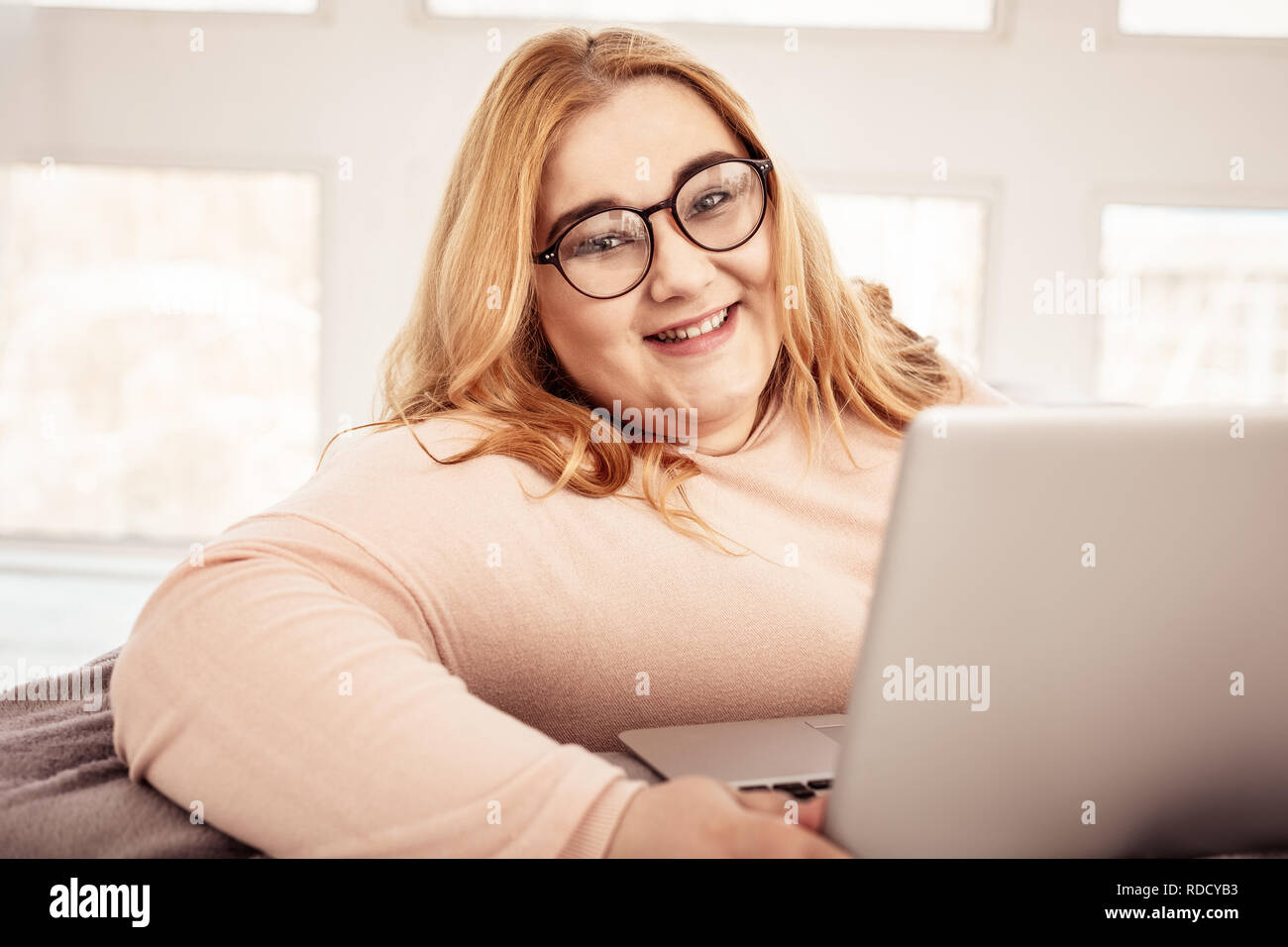 Contented ginger plus-size woman wearing clear glasses Stock Photo - Alamy