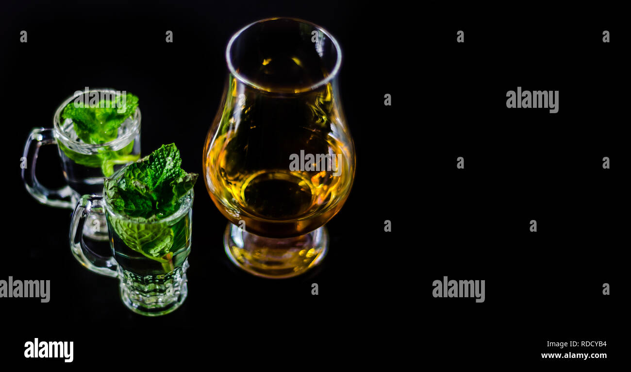 single malt whiskey in a glass and green mint liqueur, refreshing set