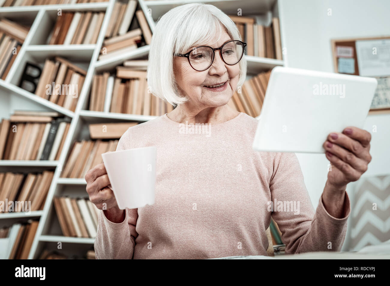 Positive delighted mature student completing home task Stock Photo