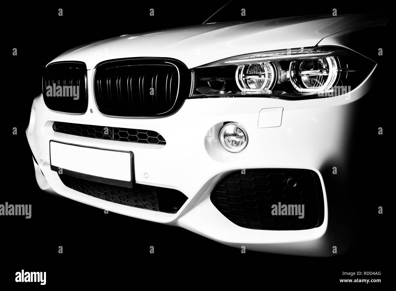 Headlight of a modern white sport car. The front lights of the car