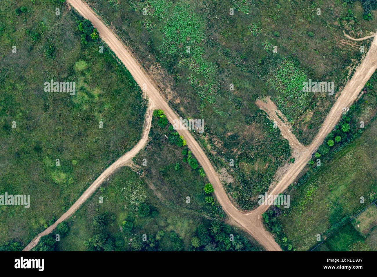 top aerial view of a dirt sandy road, green fields in summer Stock Photo