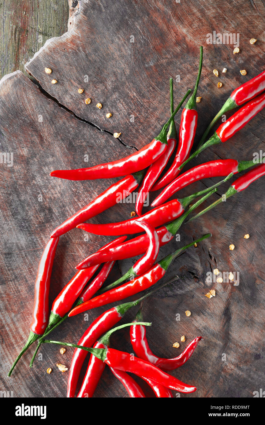 Close-up on red hot chili peppers on rustic wood, top view Stock Photo -  Alamy