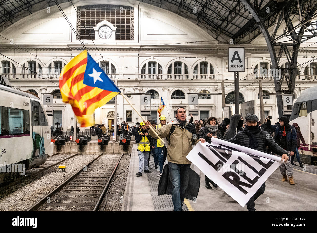 A demonstrator seen with the independence flag during the protest. At the end of a day of arrests made by the Spanish police in Girona between pro-independence supporters were several popular mobilizations that were organized in front of the police commissars demanding the freedom of the detainees and freedom of expression. In Barcelona the protest ended by protester occupying the train tracks of the Station of France. Stock Photo