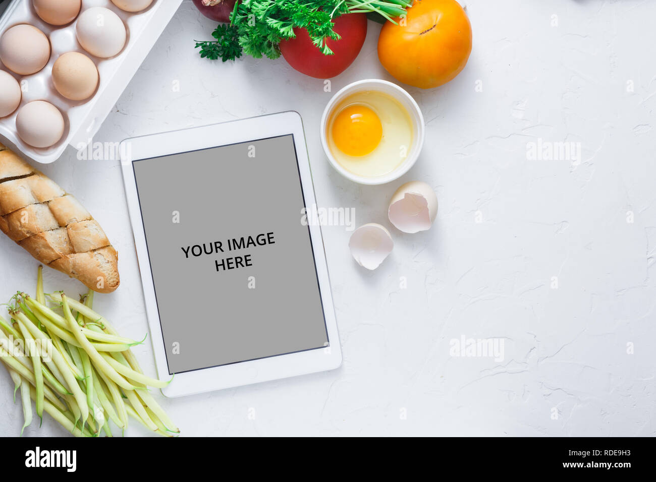 Tablet computer with fresh vegetables on white background, copy space ...