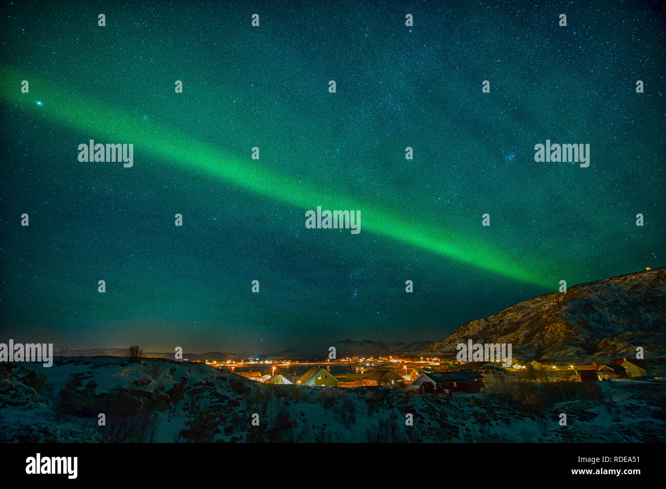 The Northern Lights trace a definite line in the sky to illuminate a city in Norway Stock Photo