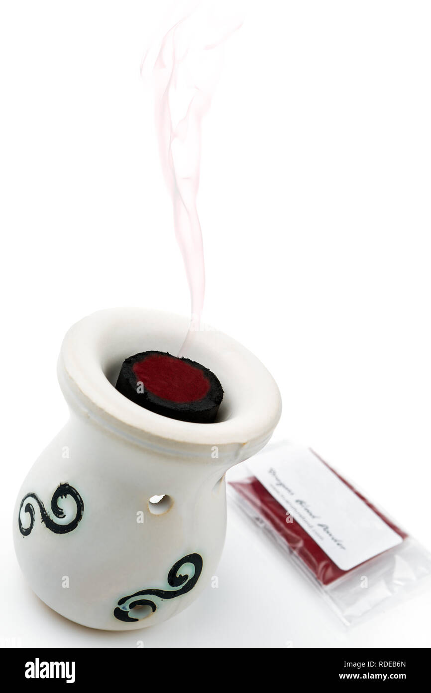 Dragon's blood powder in charcoal disc placed in oil burner on the