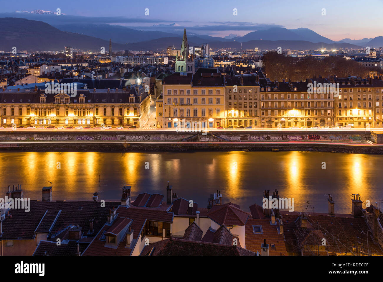 Grenoble, France, January 2019 : City at sunset with isere river and the mountains in the background. Stock Photo