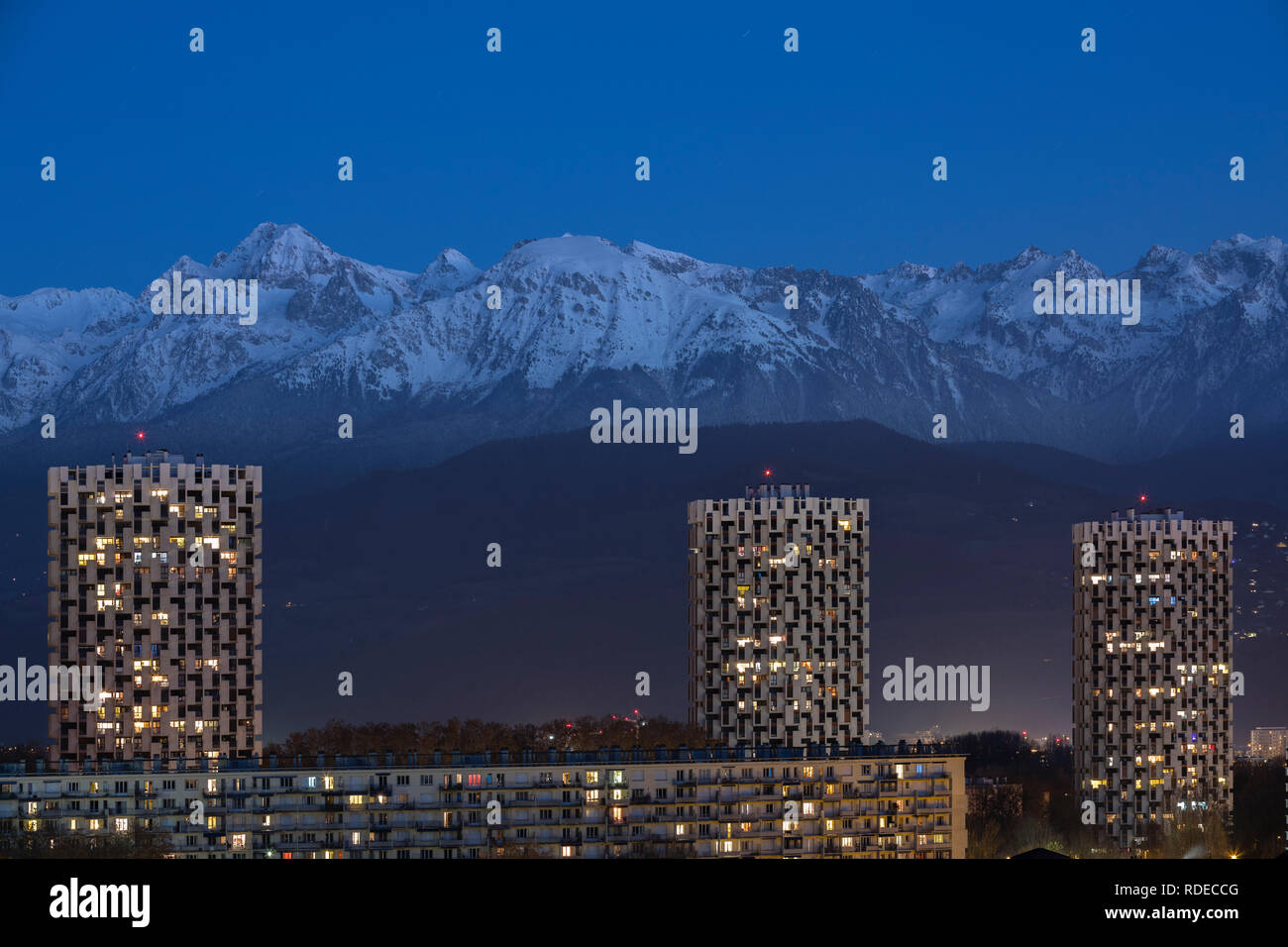 Grenoble, France, January 2019 : the three towers in front the belledonne mountains at night, ile verte neighbourhood. Stock Photo