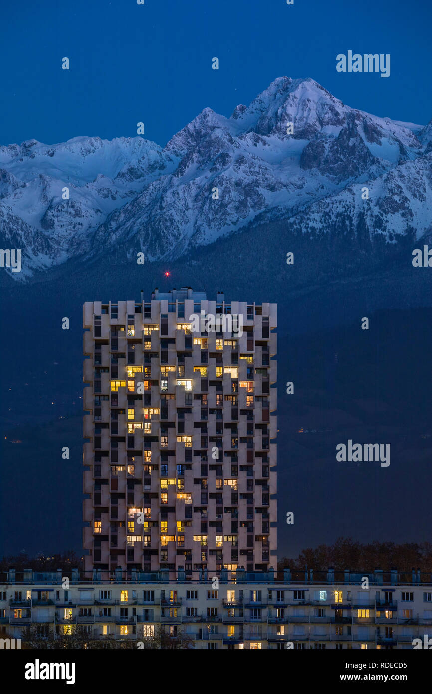 Grenoble, France, January 2019 : One of the three towers in front the belledonne mountains at night, ile verte neighbourhood. Stock Photo