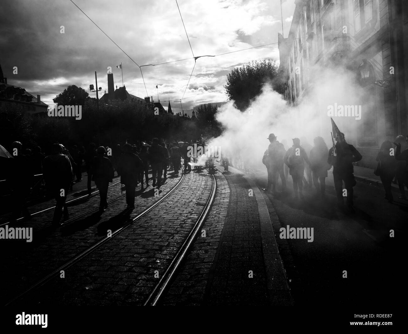 STRASBOURG, FRANCE - SEP 12, 2018: Smoke grenade thrown by people during French Nationwide day of protest against labor reform proposed by Emmanuel Macron Government - black and white  Stock Photo
