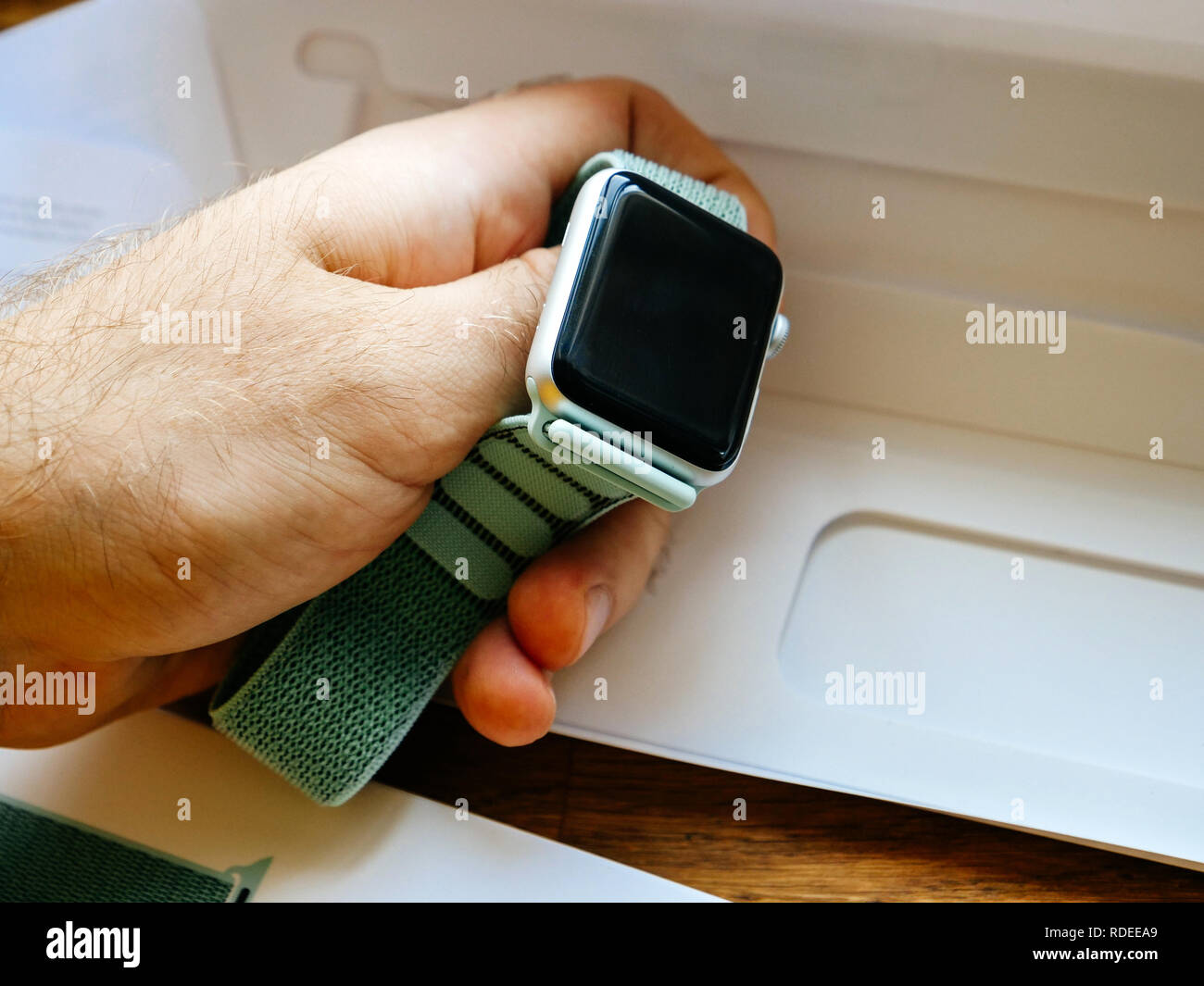 PARIS, FRANCE - APR 24, 2018: New Apple Watch Series 3 smartwatch personal  wearable device in male hand with the new 42mm Marine Green Sport Loop -  unboxing of strap Stock Photo - Alamy