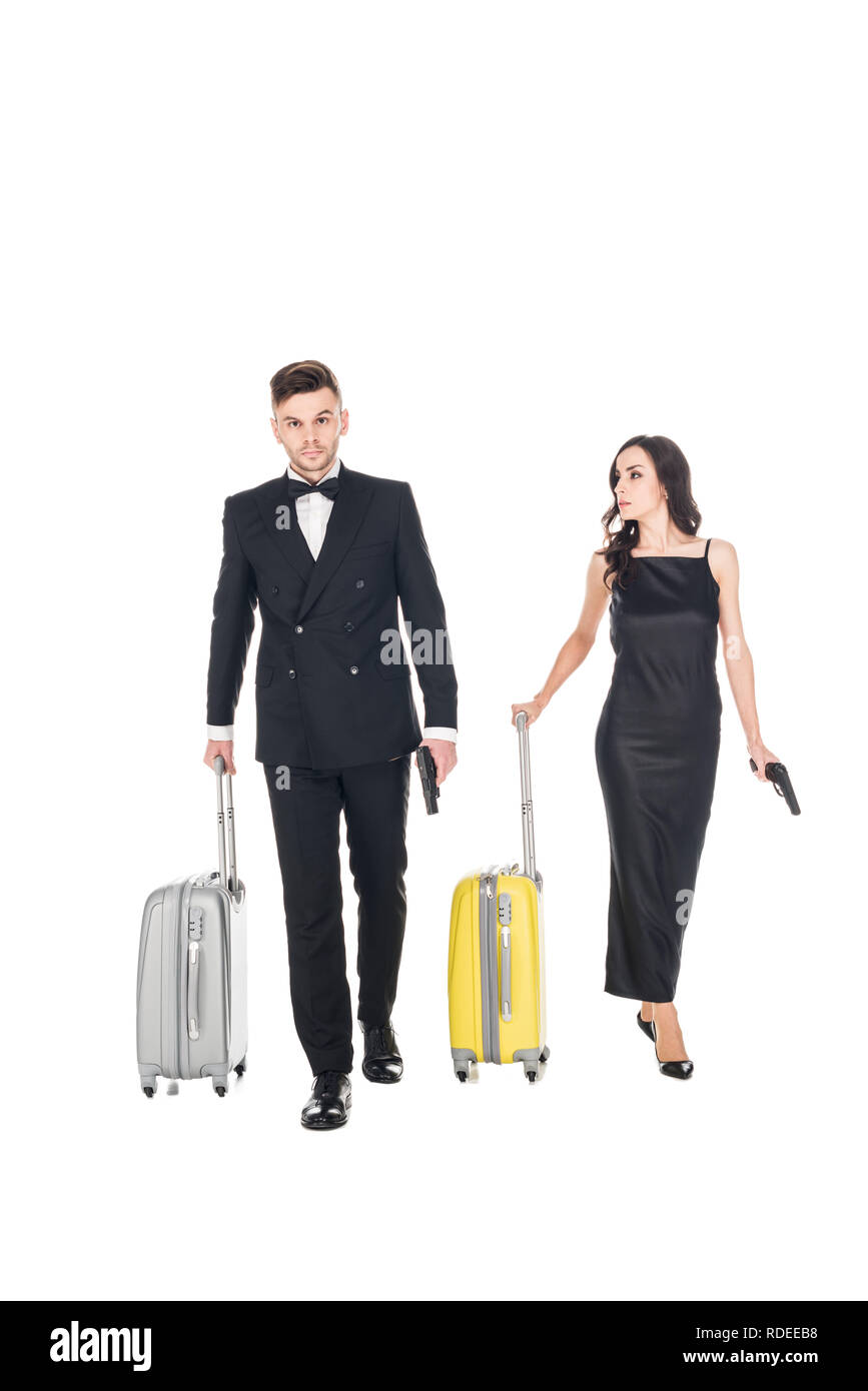 couple of killers in black clothes with guns and travel bags, isolated on white Stock Photo
