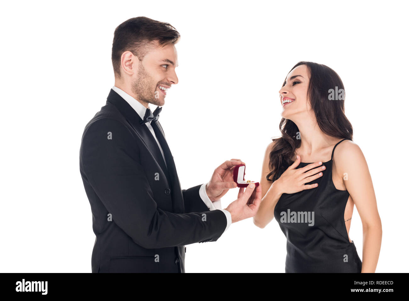 handsome boyfriend giving proposal ring in box to excited girlfriend, isolated on white Stock