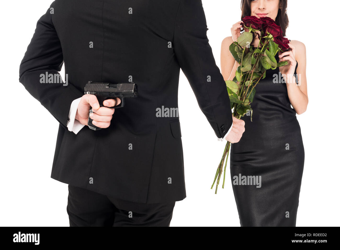 Мужчина угрожает девушку. Цветы за спиной. Мужчина с пистолетом за спиной. Держит цветы за спиной. Мужчина с оружием за спиной.
