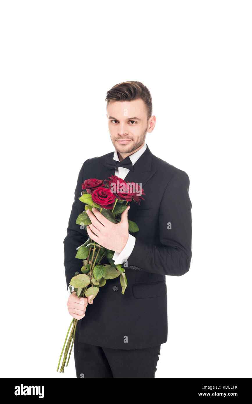 handsome elegant man in black suit holding red roses for valentines day ...