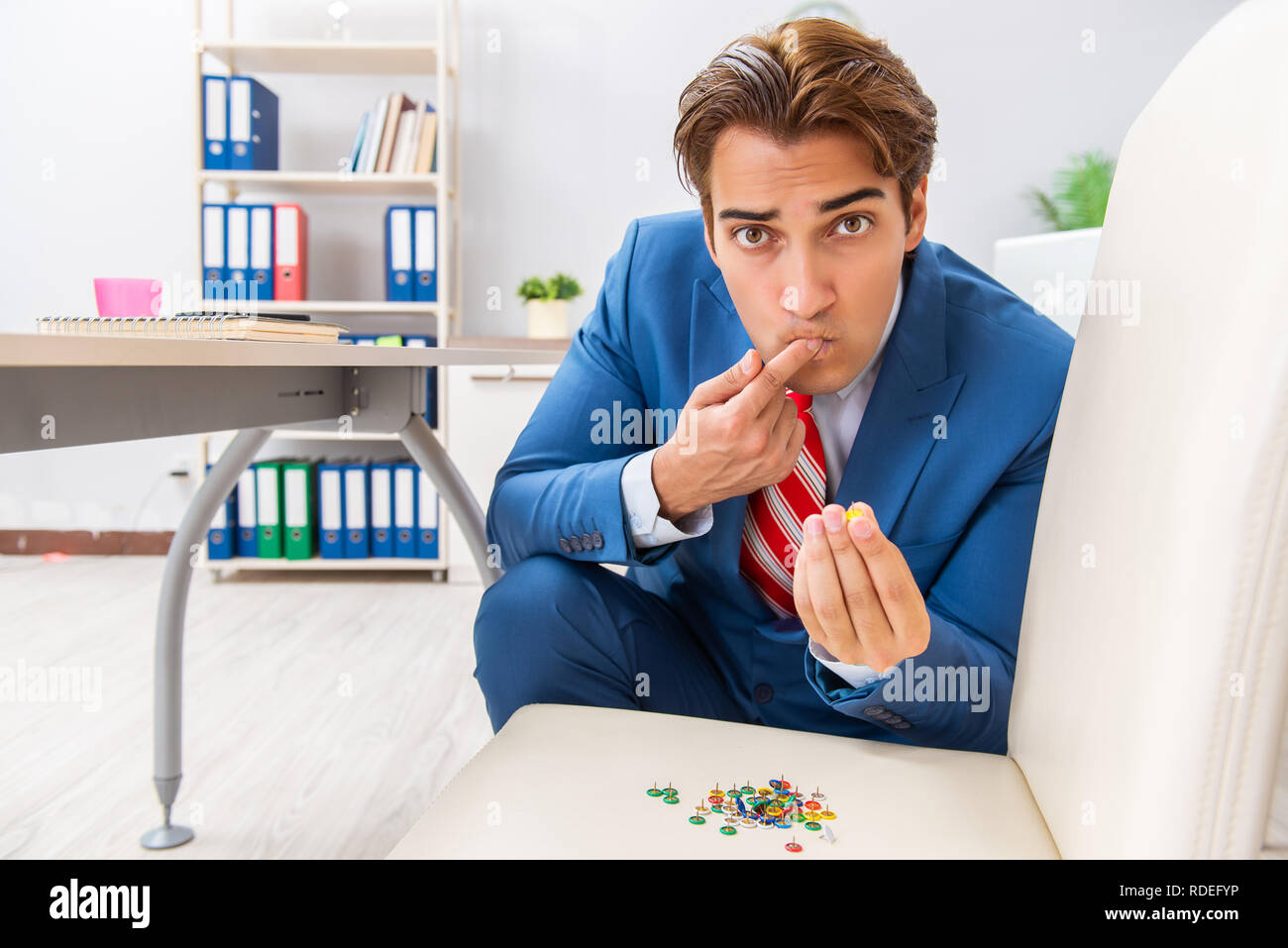 Office prank with sharp thumbtacks on chair Stock Photo Alamy