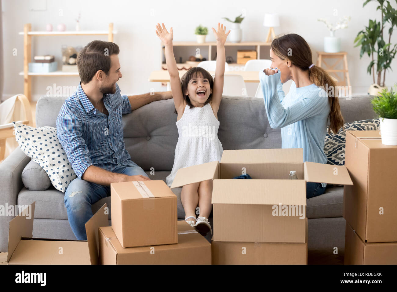 Excited kid feeling happy on moving day with mom dad Stock Photo - Alamy