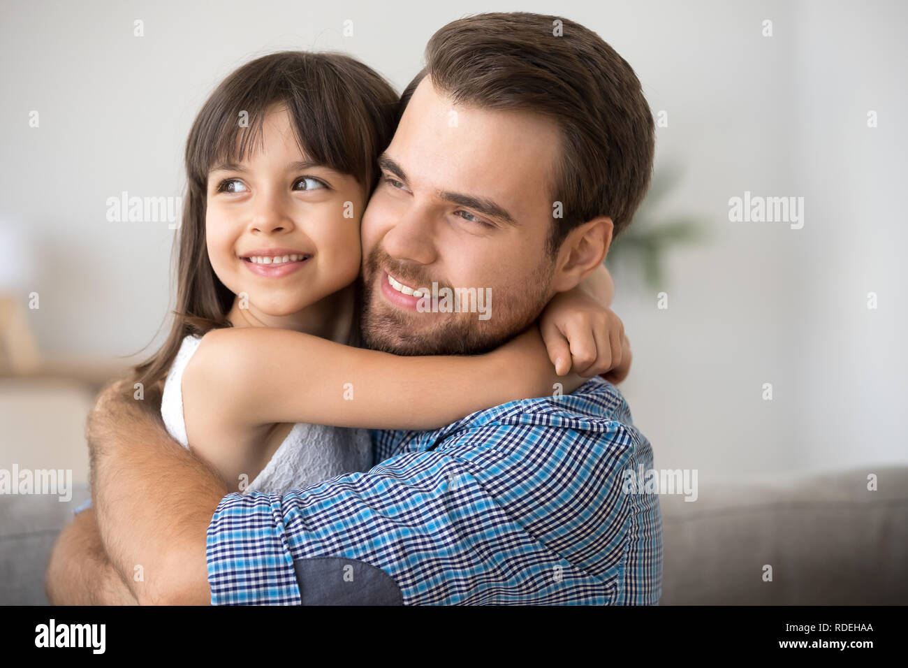 Hopeful single dad embracing kid daughter looking into bright fu Stock Photo