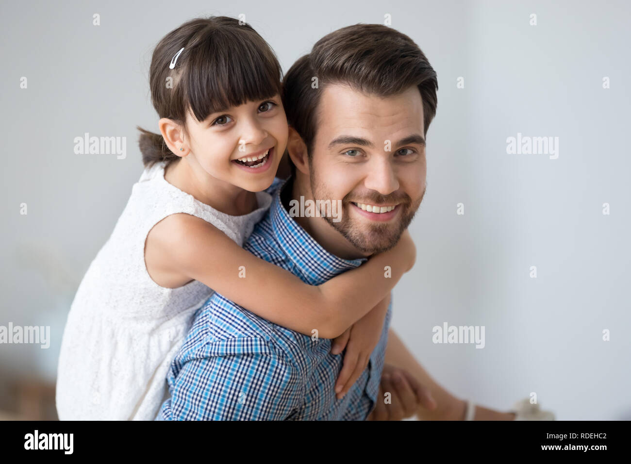 Happy dad carrying cute child on back looking at camera Stock Photo
