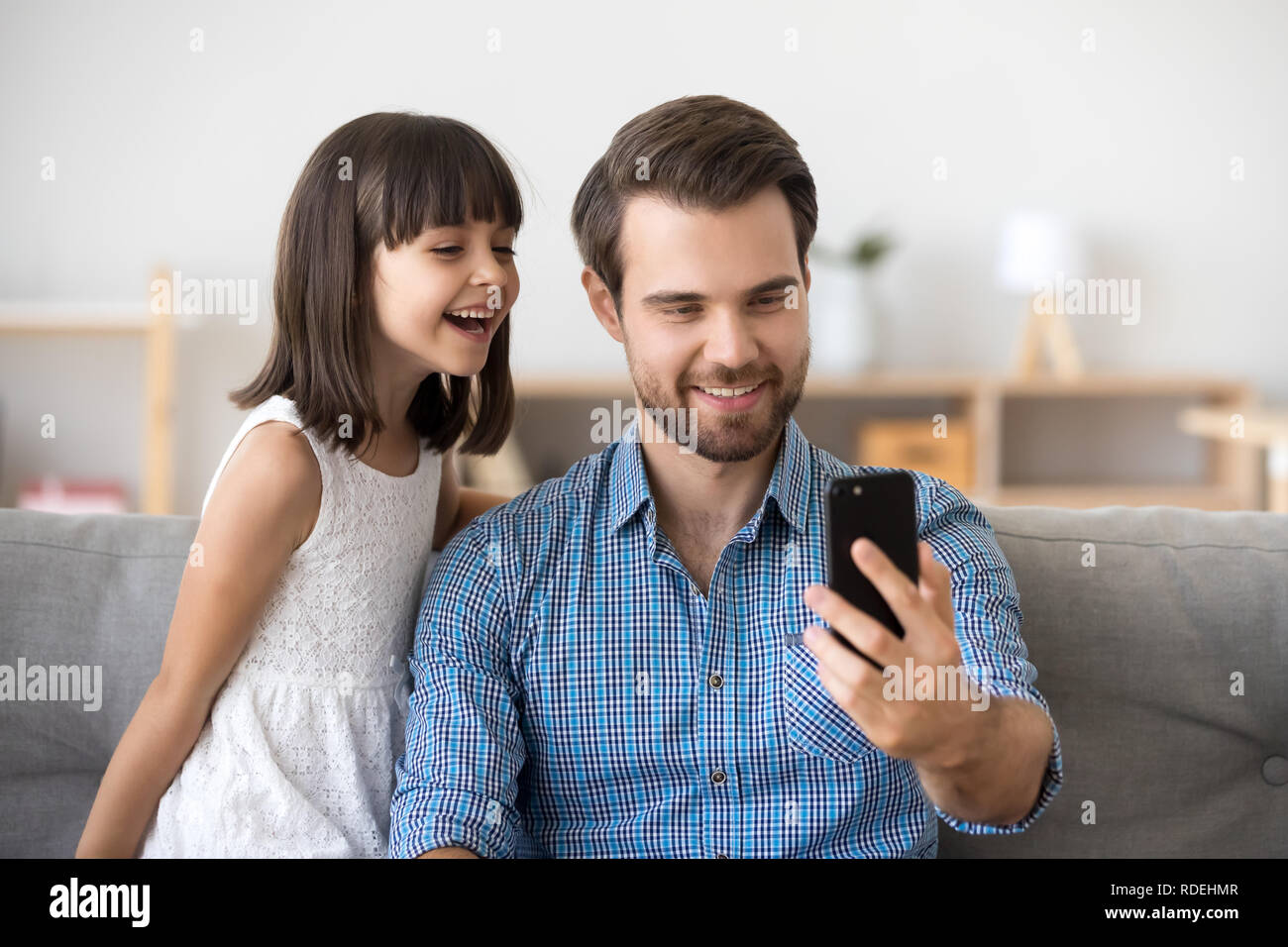Happy dad taking selfie with kid on smartphone at home Stock Photo