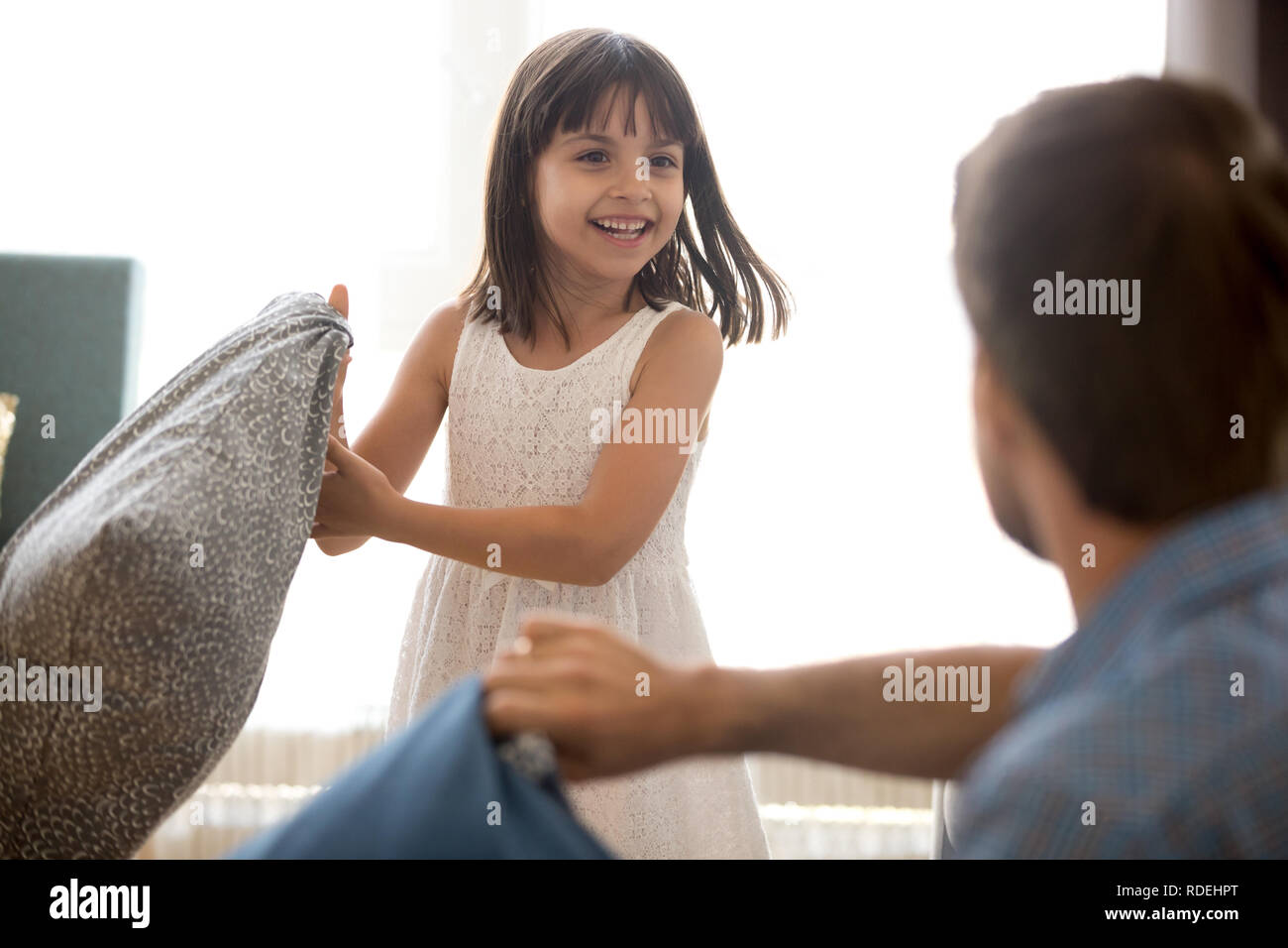 Cute child girl having funny pillow fight with dad Stock Photo Alamy