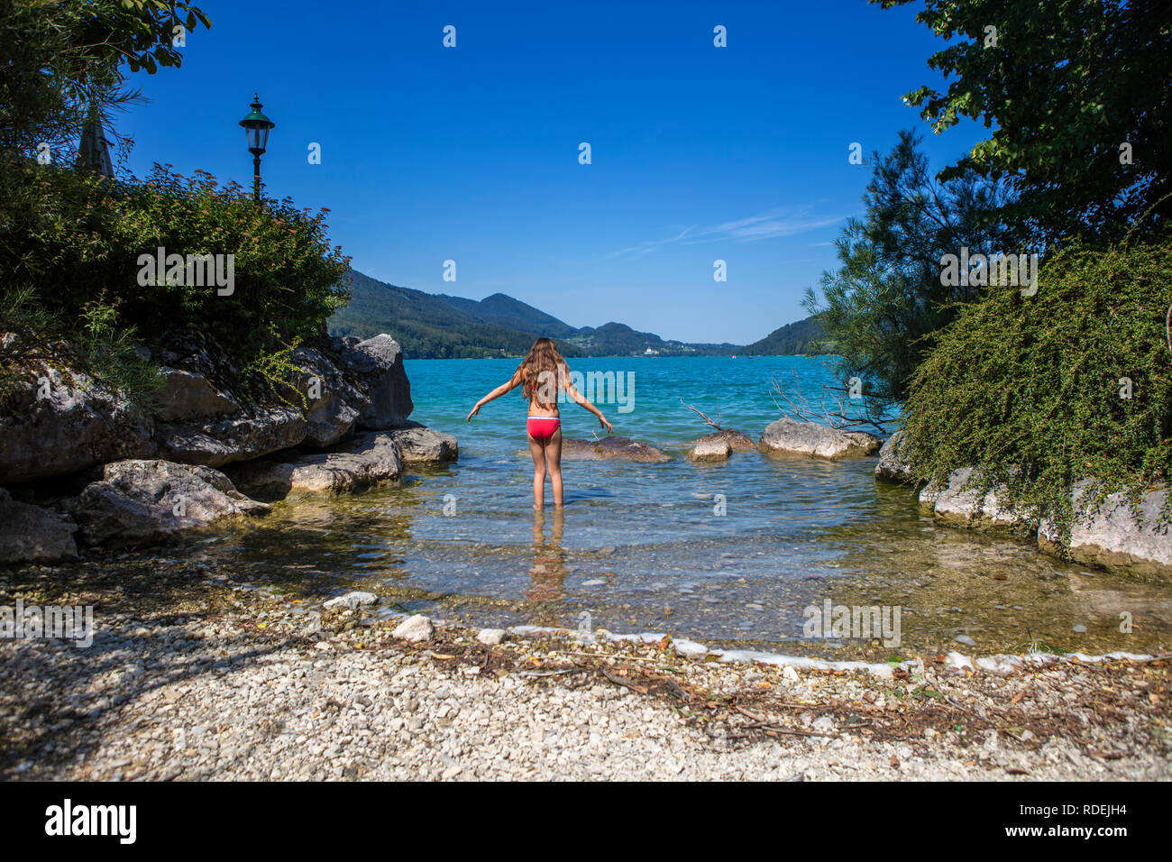 Young girl walking in the lake in Austria at Lake Wolfgang Stock Photo