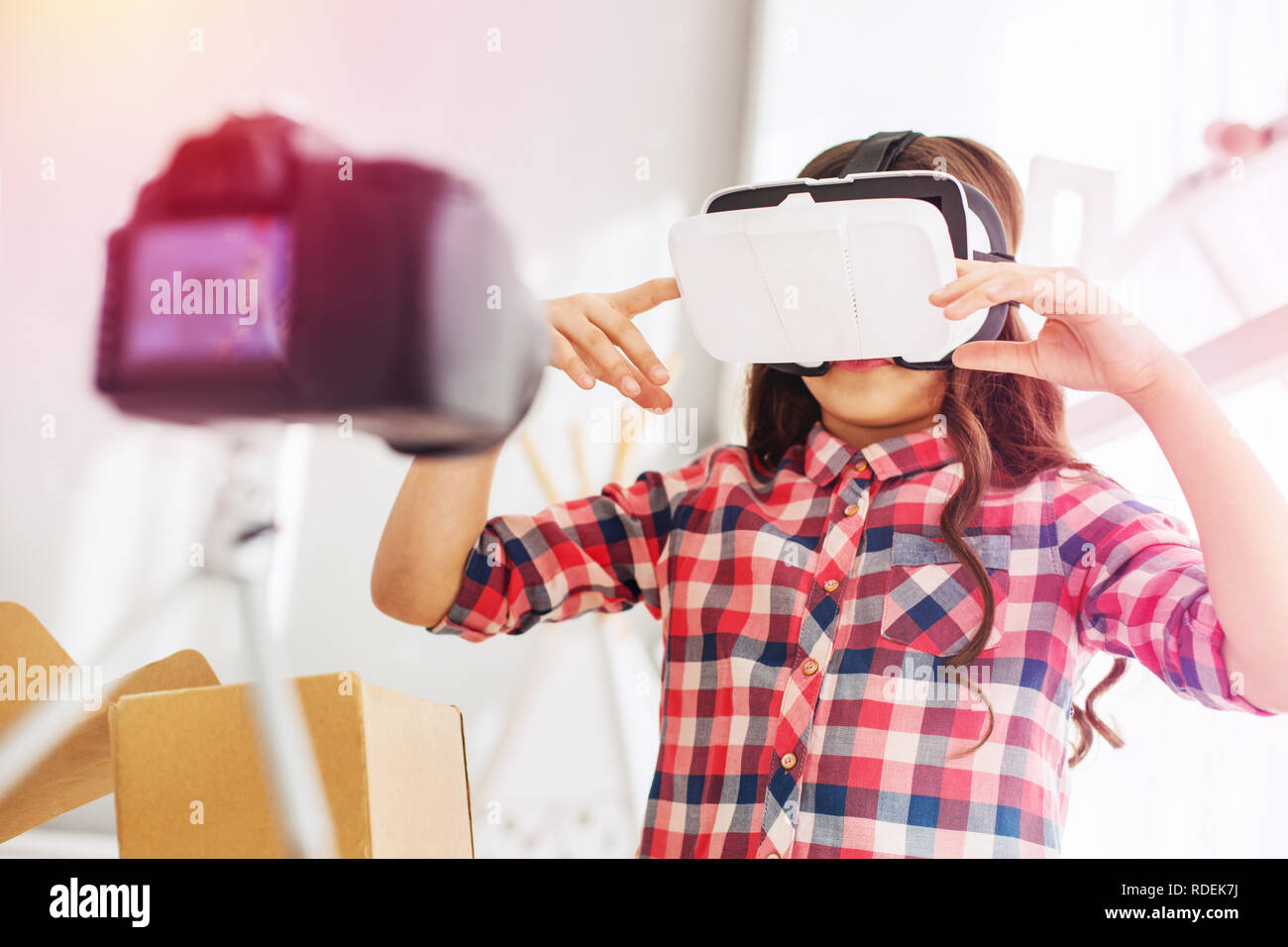 Preschool girl with long dark wavy hair standing with her virtual