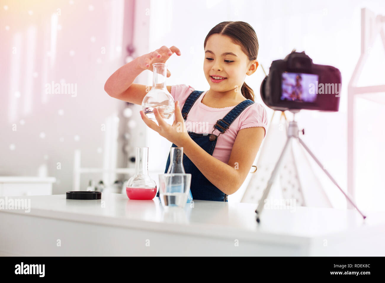 Young excited blogger filming her video while doing chemistry experiment Stock Photo