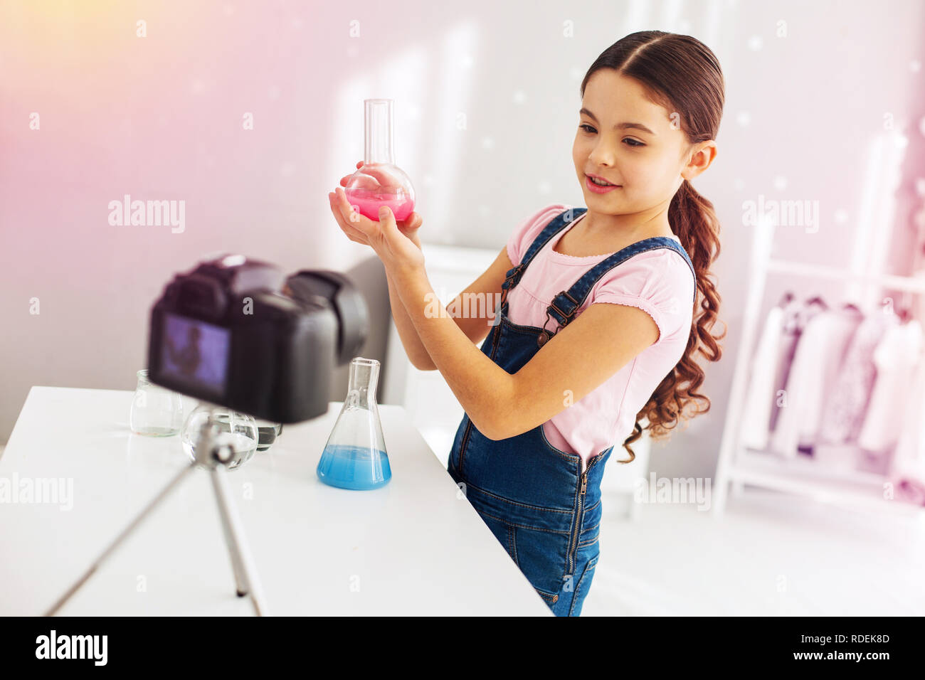 Preschool girl fond of chemistry greatly filming blog about her experiment Stock Photo