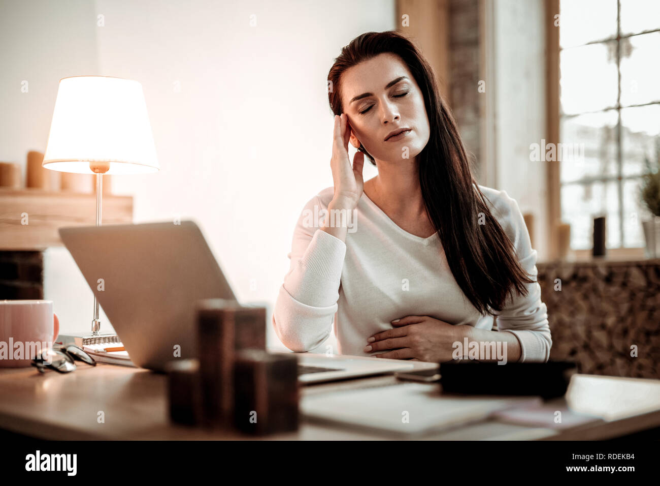 Pleasant nice young woman touching her head Stock Photo