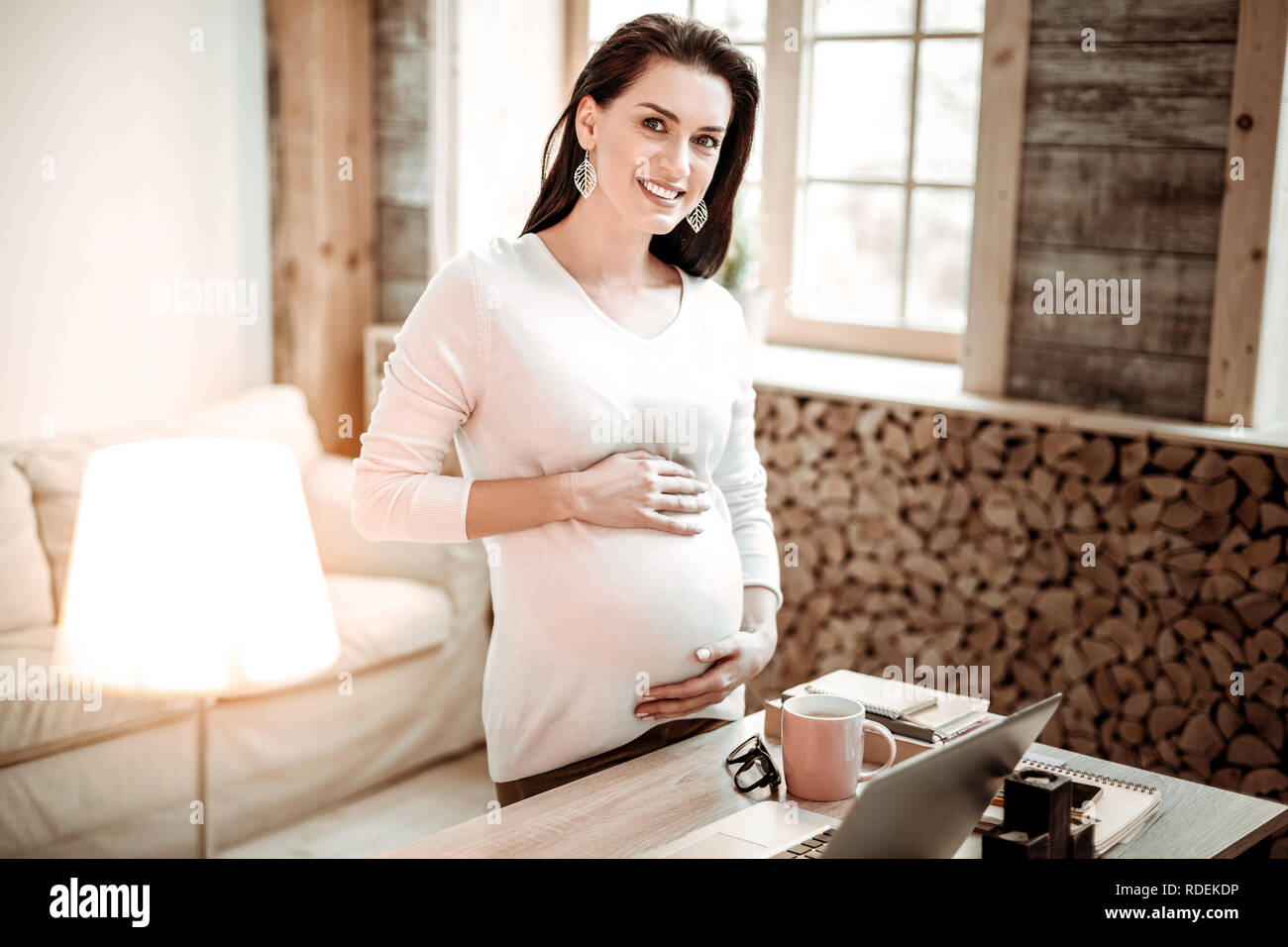 Positive joyful woman holding her big belly Stock Photo Alamy
