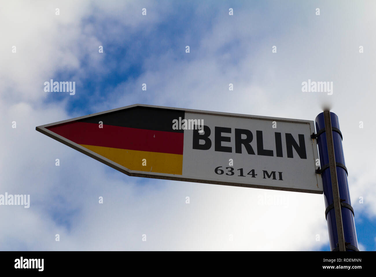 signpost, flag, berlin, flagge, miles, sky, meilen himmel wolke cloud blau schwarz rot gold black red blue Stock Photo