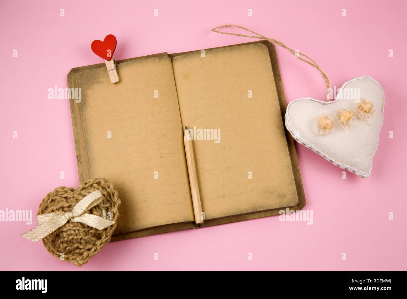 top view notebook with old vintage paper and stuffed toys hearts pastel pink background Stock Photo