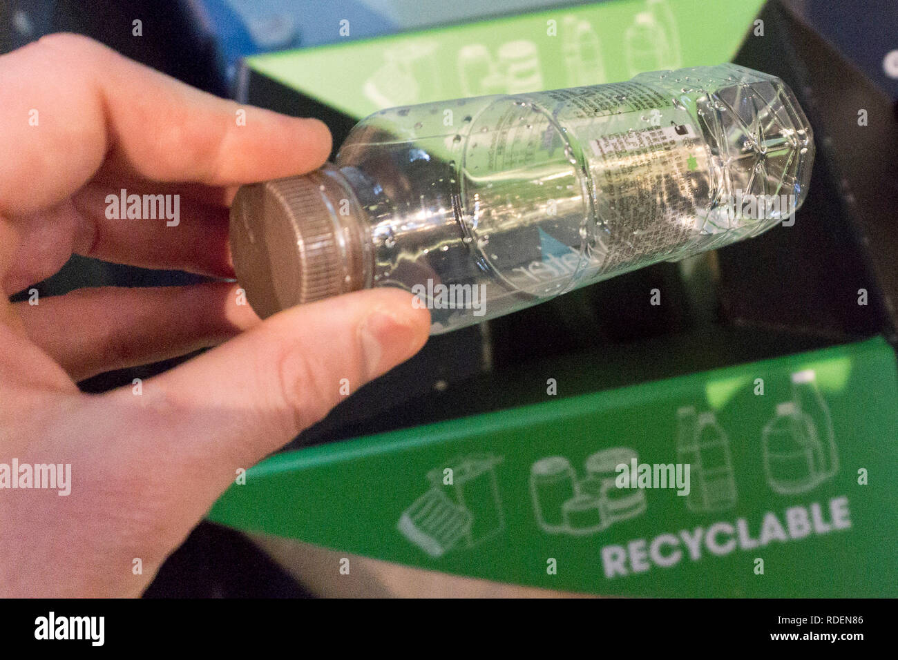Recycling a plastic bottle in a bin at a coffee shop in Dublin, Ireland