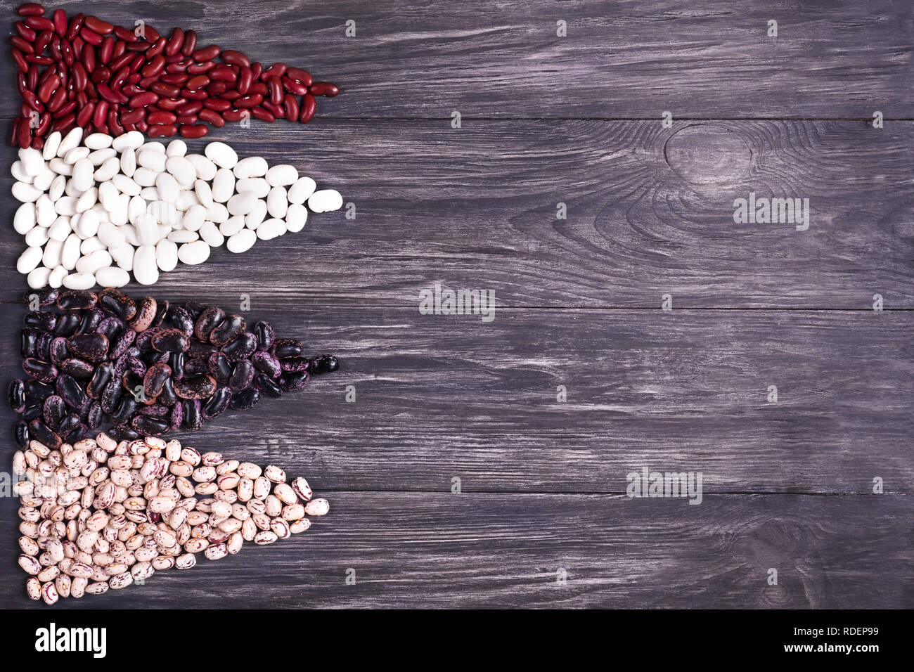 Red kidney beans,pinto beans and great  beans scattered on the dark background.Source of nutritious and a power. Stock Photo