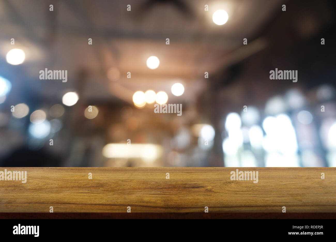 Empty dark wooden table in front of abstract blurred background of restaurant, cafe and coffee shop interior. can be used for display or montage your  Stock Photo