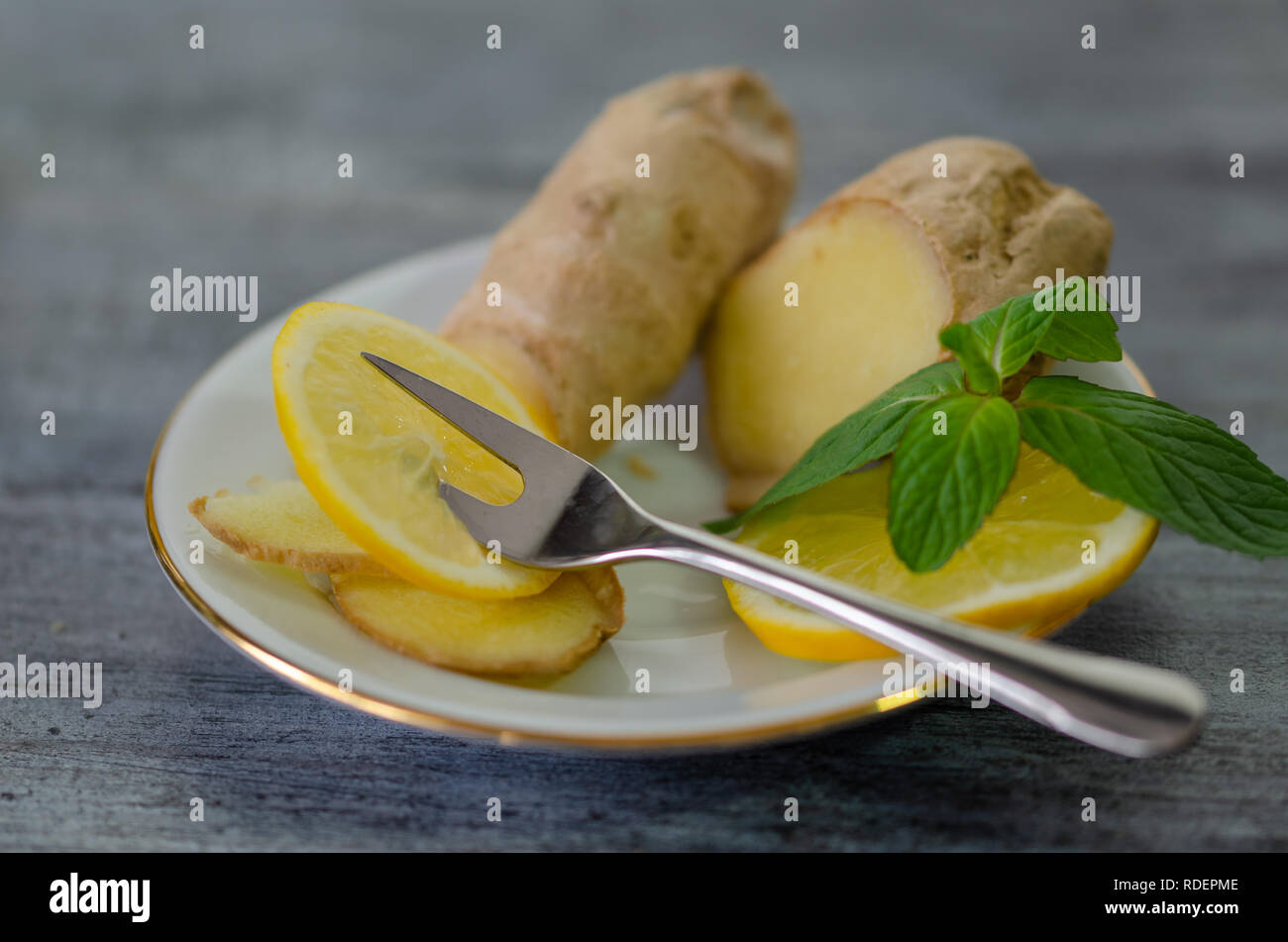 Lemons, mint and ginger on a white plate Stock Photo