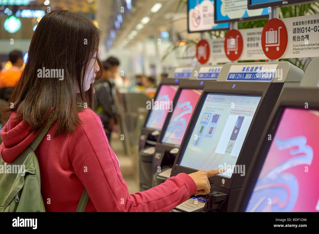 SHENZHEN, CHINA - FEBRUARY 16, 2015: woman use self check-in kiosk at ...