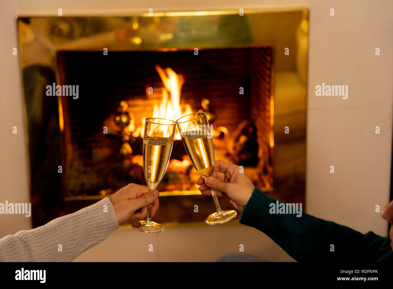 Close Up Of Romantic Couple Holding Two Champagne Glasses Toasting