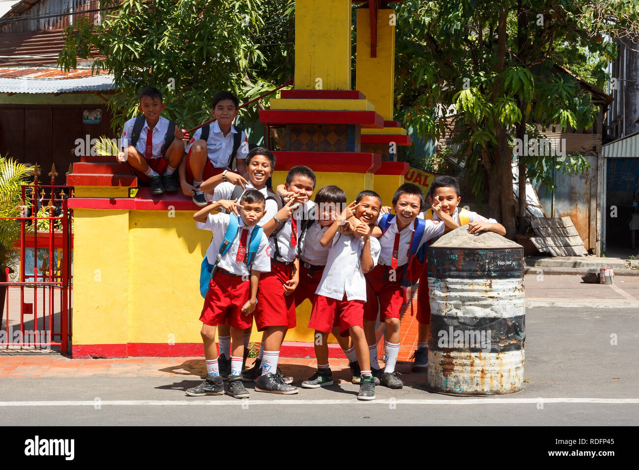 Manado, Indonesia - August 04 2015: Group of young students in uniform pose for tourist in street of Manado on North Sulawesi. Stock Photo