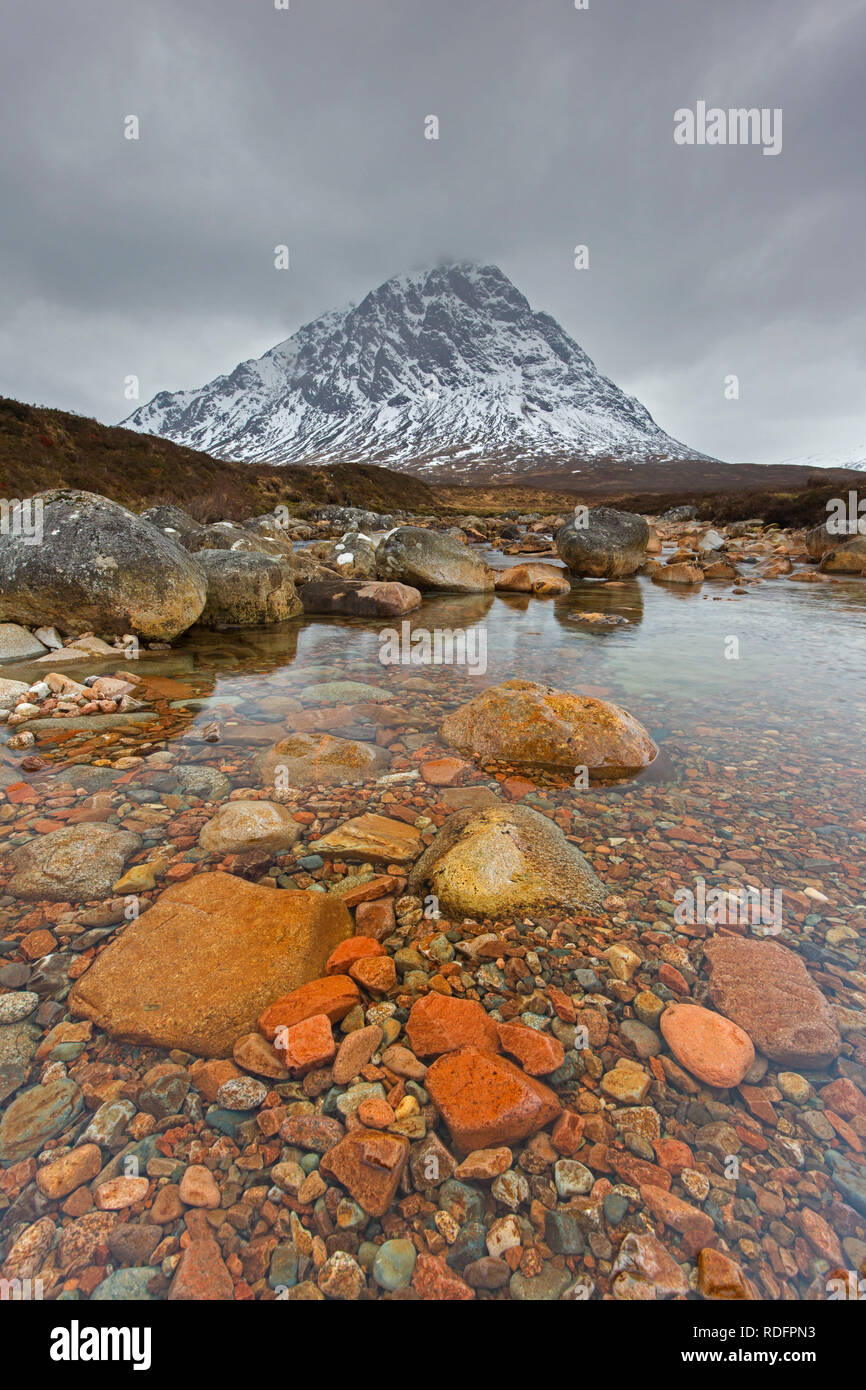 Scottish mountain Buachaille Etive Mòr and waterfall on River Coupall in winter in Glen Etive