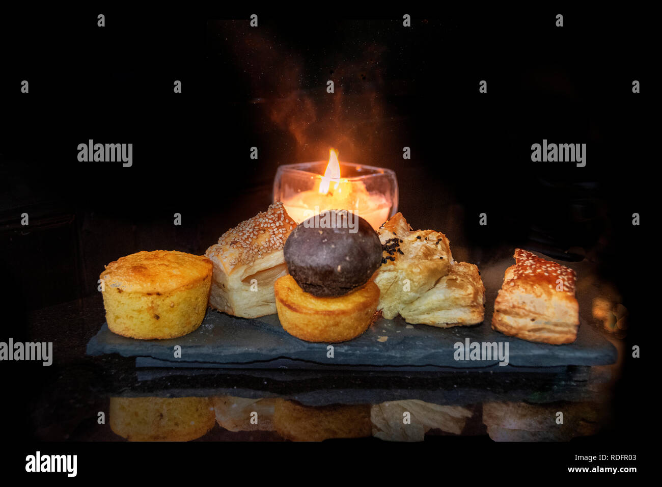many-types-of-bread-rolls-with-candle-on-elegant-black-granite-table