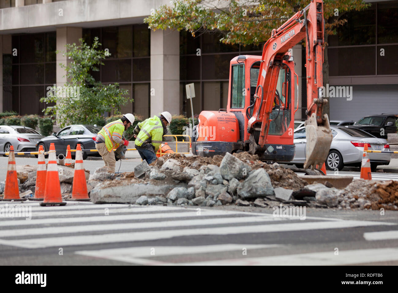 Municipal workers digging asphalt to perform underground repairs - USA Stock Photo