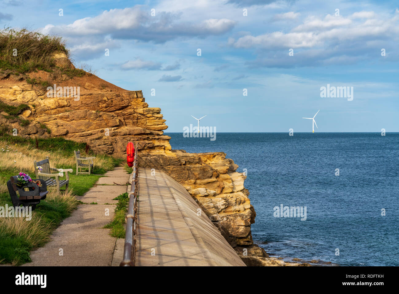 North Sea coast in Collywell Bay, Seaton Sluice in Northumberland, England, UK - with wind turbines in the background Stock Photo