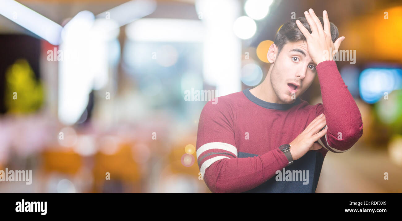 Young handsome man over isolated background surprised with hand on head for mistake, remember error. Forgot, bad memory concept. Stock Photo