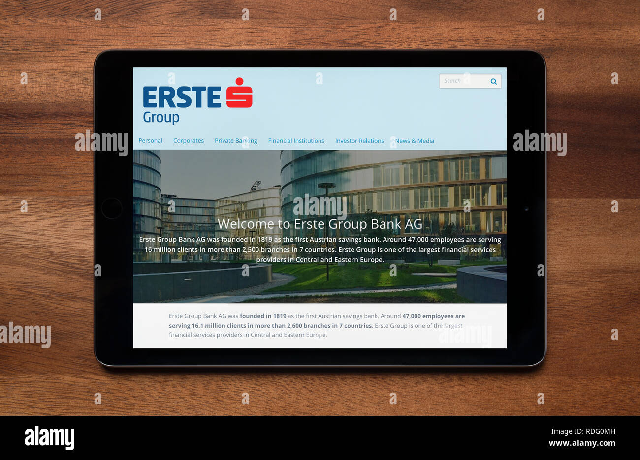 The website of Erste Group is seen on an iPad tablet, which is resting on a wooden table (Editorial use only). Stock Photo