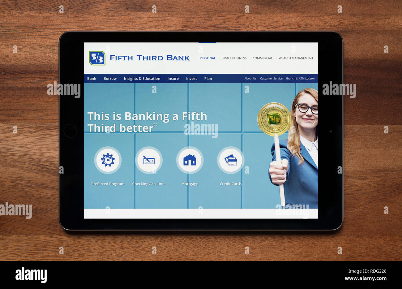The website of Fifth Third bank is seen on an iPad tablet, which is resting on a wooden table (Editorial use only). Stock Photo