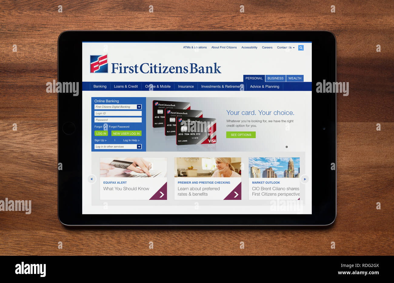 The website of First Citizens is seen on an iPad tablet, which is resting on a wooden table (Editorial use only). Stock Photo